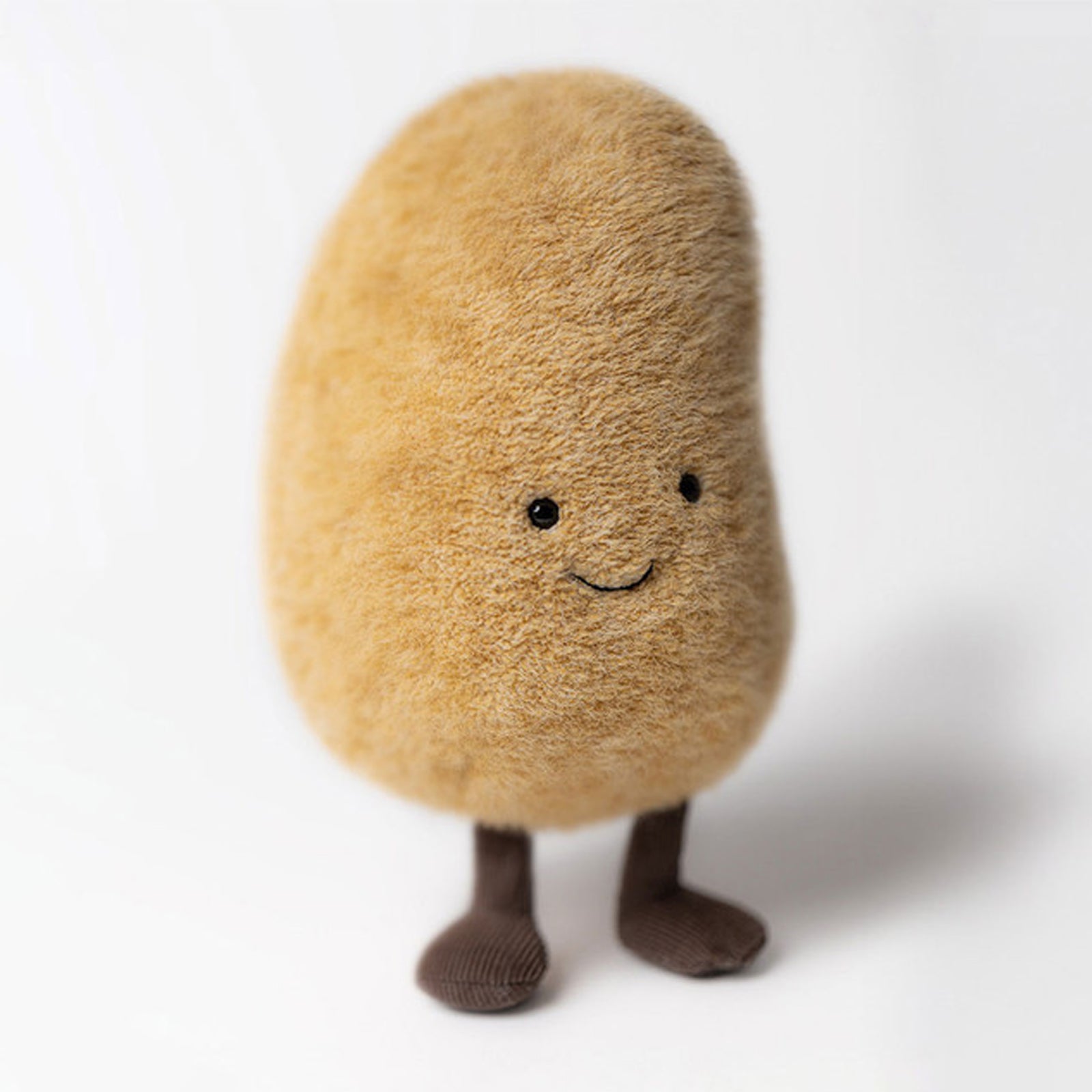 Amuseables Potato - a soft plush toy of a smiling potato with cute eyes, creating a cozy mood.